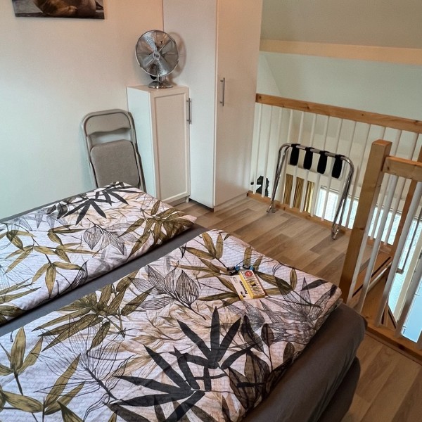 Slaapkamer op de vide met tweepersoonsbed, zeehondenschilderij en kledingkast